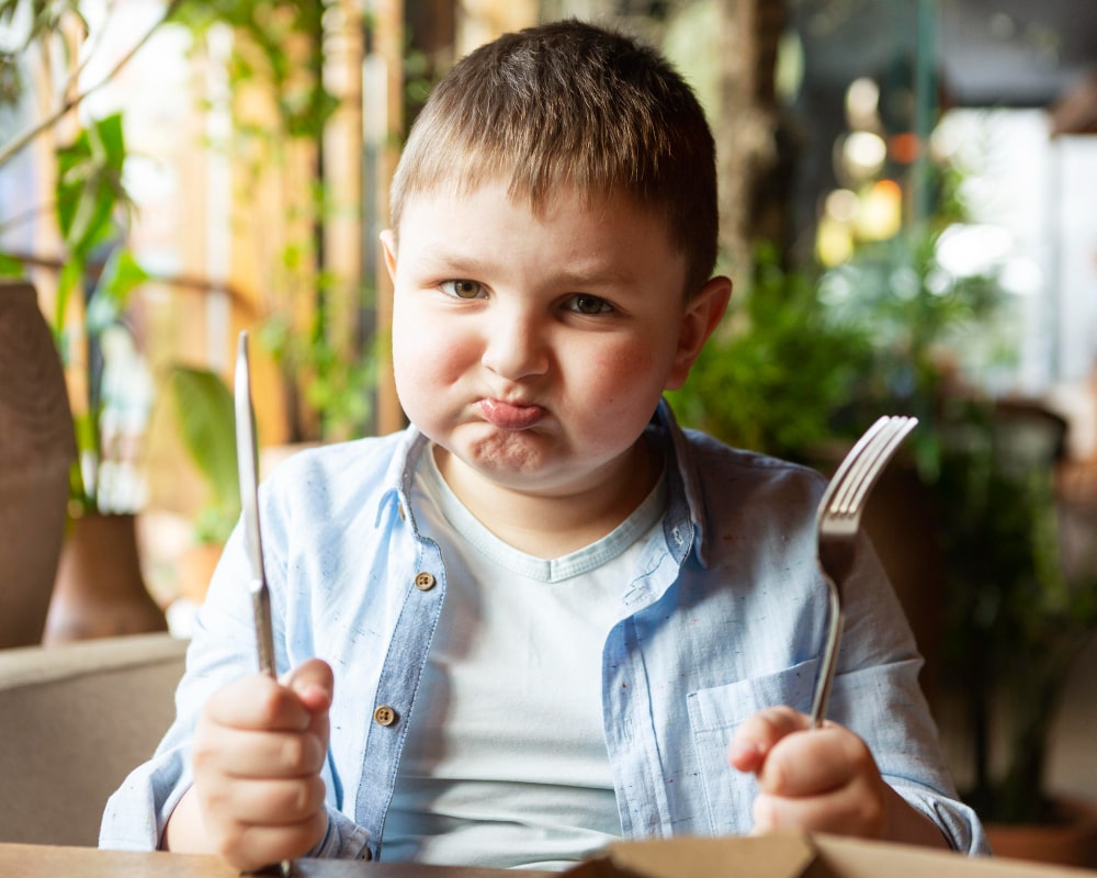 medium-shot-sad-kid-with-cutlery-min.jpg